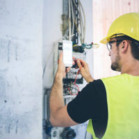 An electrician fixing up the wires and measuring volts